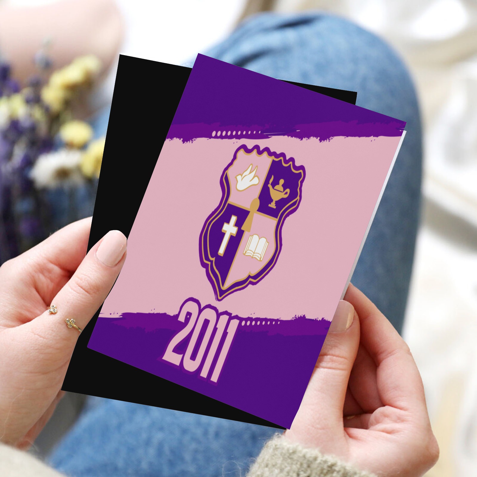 Hand holding a card with purple crest design,2011