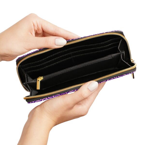 Hand holding open empty purple wallet